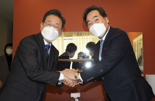 이재명(왼쪽) 더불어민주당 대선 후보와 이낙연 전 대표가 23일 서울 중구 달개비 식당에서 열린 오찬회동에서 손을 잡고 인사하고 있다. <연합뉴스>